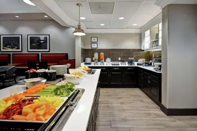 a cafeteria with a buffet of fruits and vegetables on a counter at Homewood Suites by Hilton Edgewater-NYC Area in Edgewater