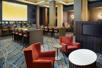 a restaurant with a bar and chairs and a flat screen tv at Hilton Parsippany in Parsippany
