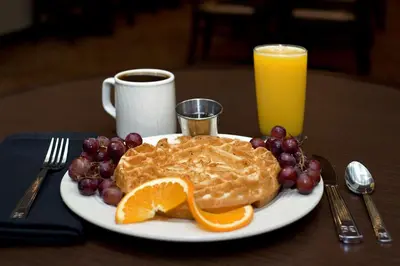 a plate of pancakes and grapes and a glass of orange juice at Hilton Garden Inn New York/Manhattan-Chelsea in New York