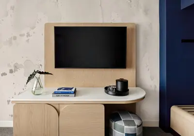 a tv on a wall with a white table at Kimpton Theta New York - Times Square by IHG in New York
