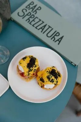 two muffins with cheese on a plate on a table at Kimpton Theta New York - Times Square by IHG in New York