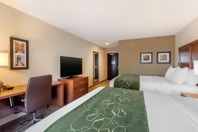 a hotel room with two beds and a desk and a television at Comfort Inn & Suites Schenectady - Scotia in Schenectady