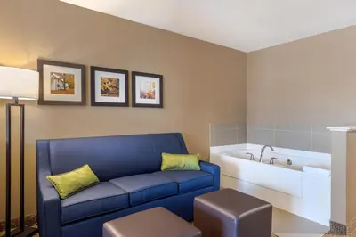 a living room with a blue couch and a bath tub at Comfort Inn & Suites Schenectady - Scotia in Schenectady