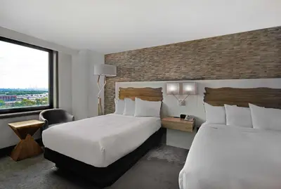 a hotel room with two beds and a large window at Hilton Hasbrouck Heights-Meadowlands in Hasbrouck Heights