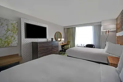 a hotel room with two beds and a television at Hilton Hasbrouck Heights-Meadowlands in Hasbrouck Heights
