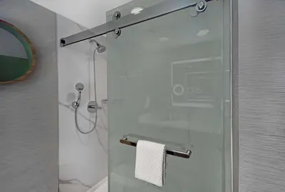 a shower with a glass door in a bathroom at Hilton Hasbrouck Heights-Meadowlands in Hasbrouck Heights