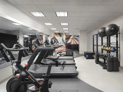 a gym with a row of treadmills and exercise bikes at Hilton Garden Inn Albany Medical Center in Albany