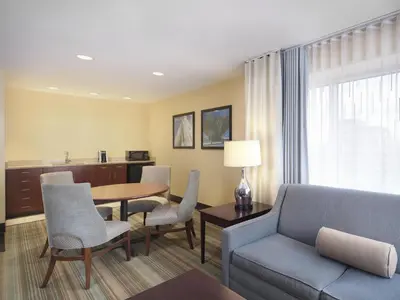 a living room with a couch and a table and chairs at Hilton Garden Inn Albany Medical Center in Albany