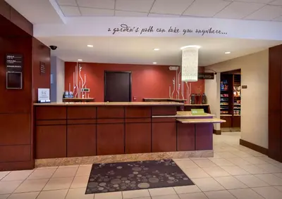 a lobby with red walls and a counter in a store at Hilton Garden Inn Albany Medical Center in Albany