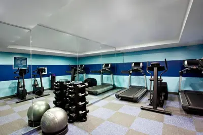 a gym with several tread machines in a room at The Chelsean New York in New York