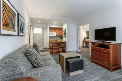 a living room with a couch and a flat screen tv at Homewood Suites by Hilton Albany in Albany