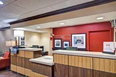 a lobby with a waiting room with red walls at Hampton Inn Albany-Wolf Road in Albany