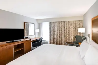 a hotel room with a bed and a desk and a television at Hampton Inn Albany-Wolf Road in Albany