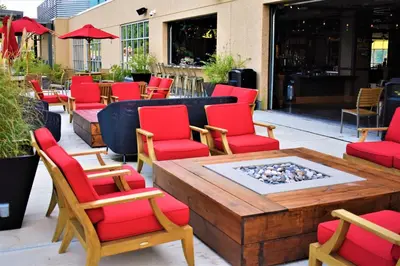 a patio with red chairs and a table with a fire pit at The Alder in Monticello