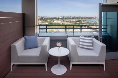 a balcony with two chairs and a table with a view at Hotel Indigo Flushing - LaGuardia in Queens