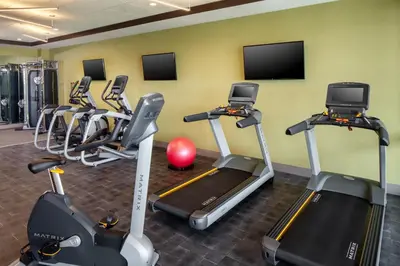 a gym with several tread machines in a room at Hotel Indigo Flushing - LaGuardia in Queens