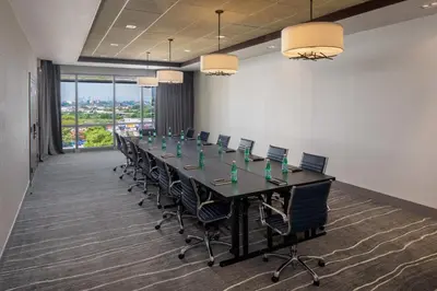 a conference room with a long table and chairs at Hotel Indigo Flushing - LaGuardia in Queens