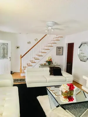 a living room with a white couch and stairs at Fearlessrose vacation Rental 89 in Springfield