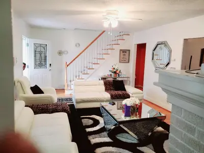 a living room with white furniture and a staircase at Fearlessrose vacation Rental 89 in Springfield