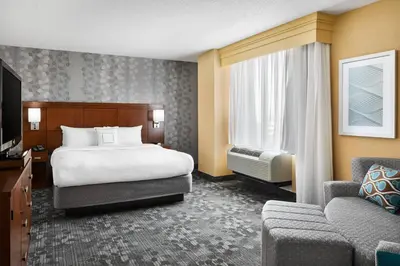 a hotel room with a bed and a couch at Courtyard by Marriott Newark Downtown in Newark