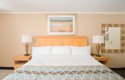 a bedroom with a large bed with two lamps at Rodeway Inn in Adams
