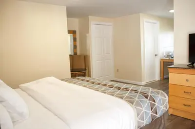 a bedroom with a bed and a dresser and a television at Rodeway Inn in Adams