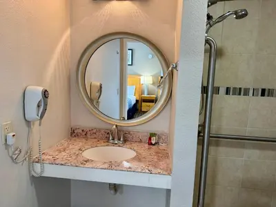 a bathroom with a sink and a mirror at Rodeway Inn in Adams