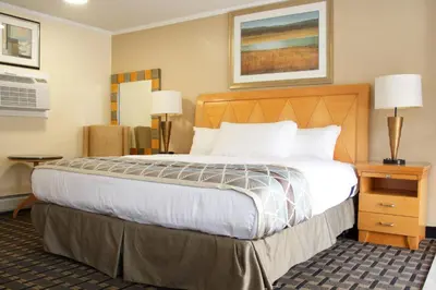 a hotel room with a large bed and two lamps at Rodeway Inn in Adams