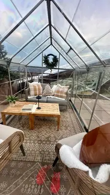 a glass roofed room with couches and tables on a boat at Ski on Ski off Mtn Chalet in Vernon
