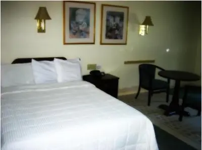 a hotel room with a bed and a table and a desk at Inn at Arbor Ridge Hotel and Conference Center in Hopewell Junction