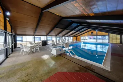 a large indoor pool with a table and chairs in a building at Red Roof Inn & Suites Newburgh - Stewart Airport West Point in New Windsor