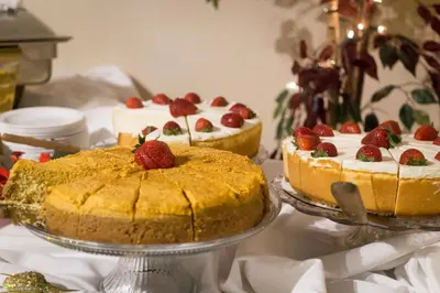 two cakes with strawberries on top on a table at Albany Plaza Hotel in Albany