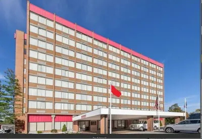 a large building with a red flag in front of it at Albany Plaza Hotel in Albany
