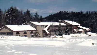 a house covered in snow in a snowy field at Austrian Haus Lodge in West Dover