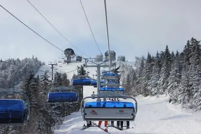 a ski lift with people on it in the snow at Austrian Haus Lodge in West Dover