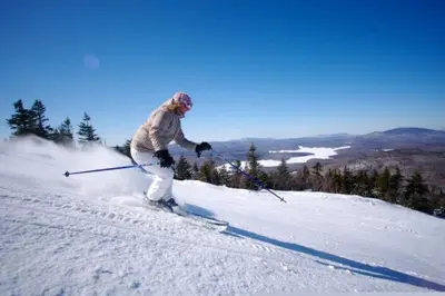 a person is skiing down a snow covered slope at Austrian Haus Lodge in West Dover