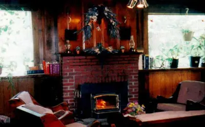 a living room with a brick fireplace and chairs at Austrian Haus Lodge in West Dover