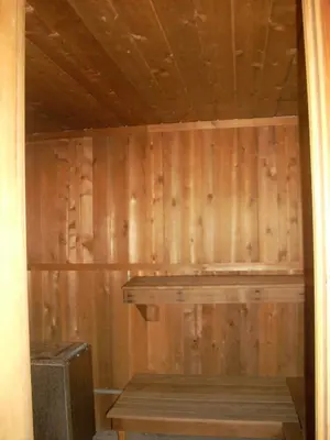 a sauna with wooden walls and a wooden bench at Austrian Haus Lodge in West Dover