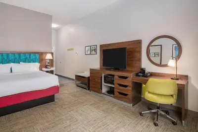 a hotel room with a bed and a desk with a television at Hampton Inn & Suites Hartford-Manchester in Manchester