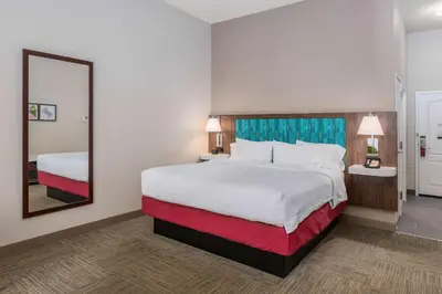 a hotel room with a large bed and a mirror at Hampton Inn & Suites Hartford-Manchester in Manchester