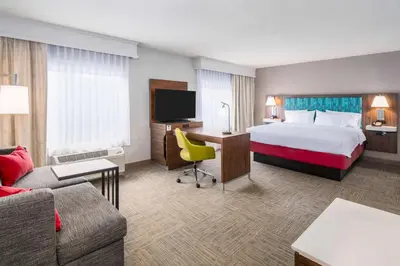 a hotel room with a bed and a desk with a tv at Hampton Inn & Suites Hartford-Manchester in Manchester