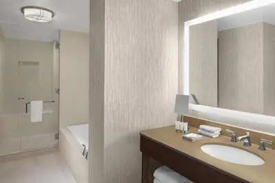 a bathroom with a sink and a tub and a mirror at The Westin New York Grand Central in New York