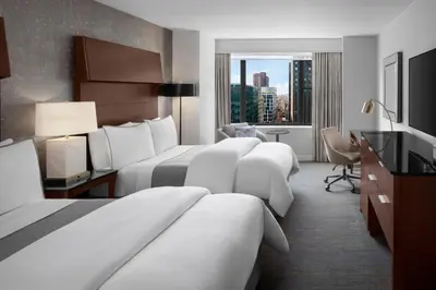 a hotel room with two beds and a desk with a desk at The Westin New York Grand Central in New York