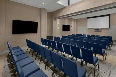 an empty lecture hall with blue chairs and a screen at Courtyard by Marriott New York World Trade Center Area in New York