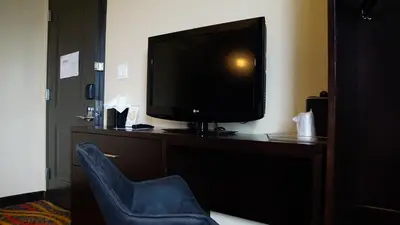 a television sitting on a desk with a chair at Nesva Hotel - New York City Vista in Queens