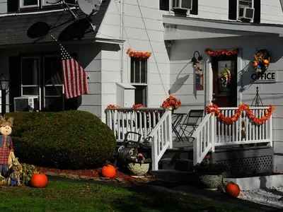 a house with an american flag and a porch with pumpkins at Willows Motel in Williamstown
