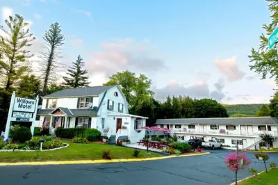 a inn with a sign in front of a building at Willows Motel in Williamstown