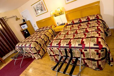 a bedroom with two beds and a table in it at Willows Motel in Williamstown