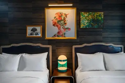 two beds in a hotel room with paintings on the wall at Renaissance New York Chelsea Hotel in New York