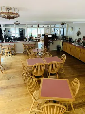 a room with tables and chairs and a kitchen at Stay Berkshires in Williamstown